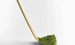 Drewniany chashaku nabiera zielony proszek matcha.