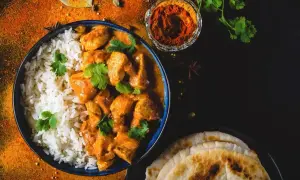 Aksamitny butter chicken, przepis oryginalny, podany z ryżem i chlebkiem naan. Aromatyczne przyprawy dopełniają danie.
