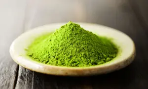 Góra zielonego proszku matcha na talerzyku. Czy matcha pobudza? Ten intensywny kolor sugeruje, że tak!