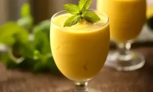 Orzeźwiający mango lassi z pulpy, udekorowany listkami mięty. Idealny na upalne dni.