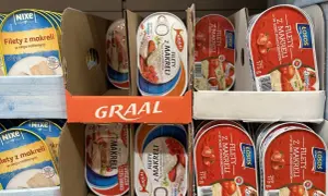 Półka sklepowa z różnymi rodzajami ryb w puszce: filety z makreli w oleju roślinnym i w sosie pomidorowym.