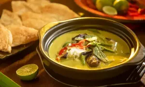 Aksamitne tajskie curry z mlekiem kokosowym, pełne warzyw i ziół, podane z chrupiącym pieczywem i limonką.