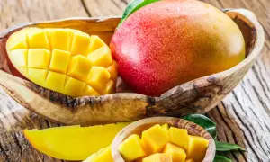 Słodkie, soczyste mango w drewnianej misce. Idealne na codzienne jedzenie mango, pełne witamin i słońca.