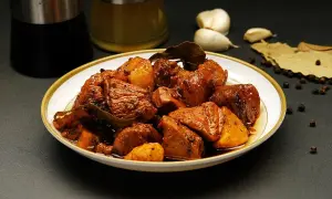 Talerz pełen mięsa w sosie, z dodatkiem czosnku, liści laurowych i pieprzu. To danie, które z pewnością wzbogaci smak dzięki przyprawie adobo.