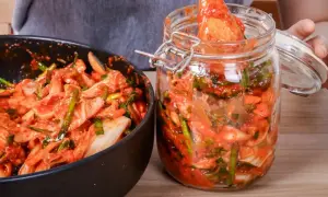 Przygotowanie domowego kimchi. W misce i słoiku widać warzywa z czerwoną pastą, kluczowe przyprawy do kimchi.