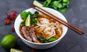 Aromatyczna zupa pho bo z wołowiną, makaronem ryżowym, limonką i świeżą kolendrą.