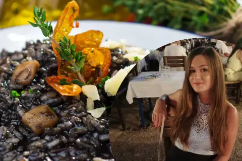 Pyszne risotto z **atramentem kałamarnicy**, ozdobione ziołami i pomidorkami, obok uśmiechniętej kobiety siedzącej w restauracji.