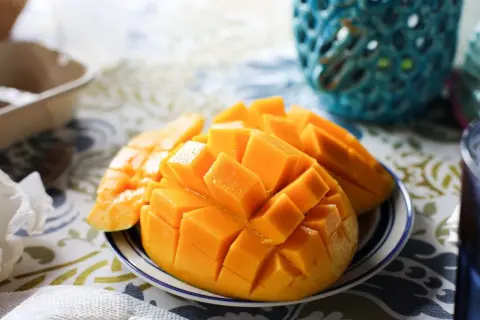 Pokrojone w kostkę mango na talerzyku, idealne na zdrową przekąskę. Sprawdź, ile ma mango kcal!
