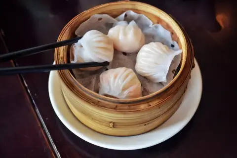 Pyszne dim sum w bambusowym parowniku, gotowe do podniesienia pałeczkami.