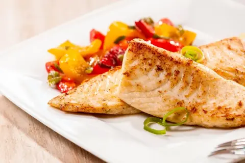 Smażona tilapia, delikatna ryba, podana z kolorowymi warzywami. Czy tilapia to ryba dla Ciebie?