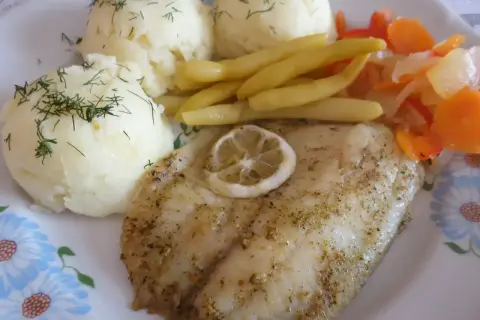 Smażony suflak z cytryną, podany z puree ziemniaczanym i warzywami.