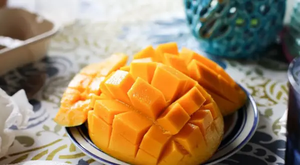 Pokrojone w kostkę mango na talerzyku, idealne na zdrową przekąskę. Sprawdź, ile ma mango kcal!
