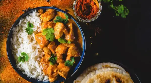 Aksamitny butter chicken, przepis oryginalny, podany z ryżem i chlebkiem naan. Aromatyczne przyprawy dopełniają danie.