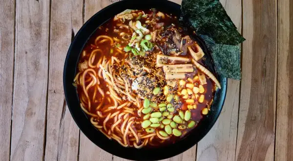 Miseczka aromatycznego ramen z makaronem, edamame, kukurydzą, grzybami i nori. Pyszny posiłek, który może mieć różną liczbę ramen kcal.