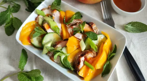 Pyszna sałatka z mango i kurczakiem, z dodatkiem ogórka, szczypiorku i mięty. Idealna na lekki posiłek.