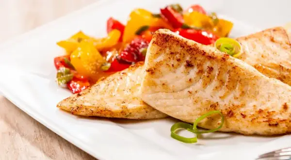 Smażona tilapia, delikatna ryba, podana z kolorowymi warzywami. Czy tilapia to ryba dla Ciebie?