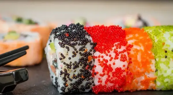 Kolorowe rolki sushi z ikrą tobiko: czarną, czerwoną, pomarańczową i zieloną. Pyszne!