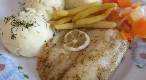 Smażony suflak z cytryną, podany z puree ziemniaczanym i warzywami.