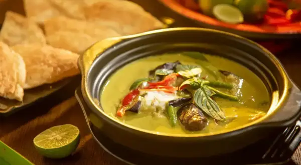 Aksamitne tajskie curry z mlekiem kokosowym, pełne warzyw i ziół, podane z chrupiącym pieczywem i limonką.