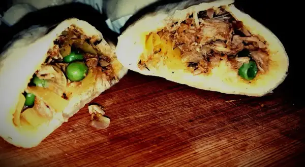 Pyszne bułeczki baozi z soczystym mięsem i groszkiem, przekrojone na pół, prezentują bogactwo nadzienia.
