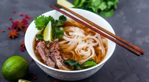 Aromatyczna zupa pho bo z wołowiną, makaronem ryżowym, limonką i świeżą kolendrą.