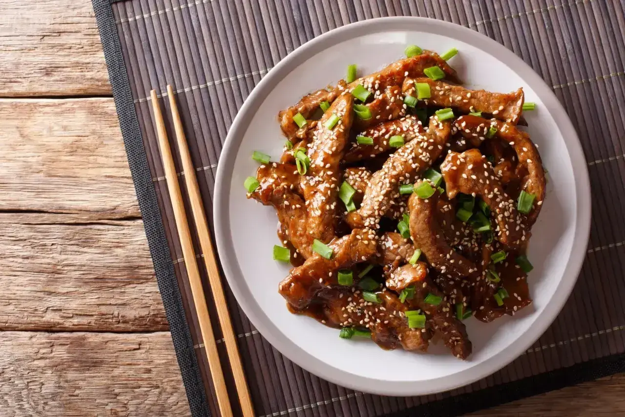 Wołowina w sosie teriyaki, posypana sezamem i szczypiorkiem. Pyszne danie, które warto znać pod kątem sos teriyaki kcal.