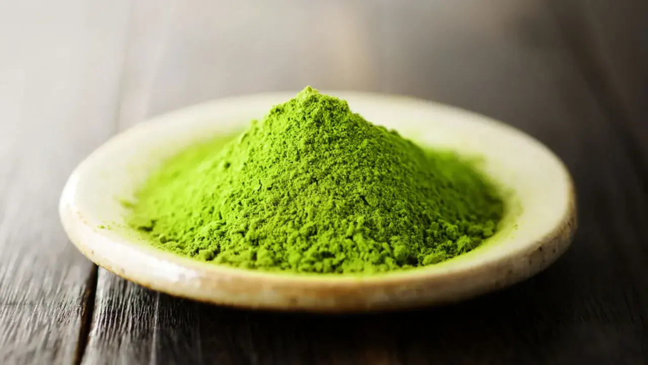 Góra zielonego proszku matcha na talerzyku. Czy matcha pobudza? Ten intensywny kolor sugeruje, że tak!