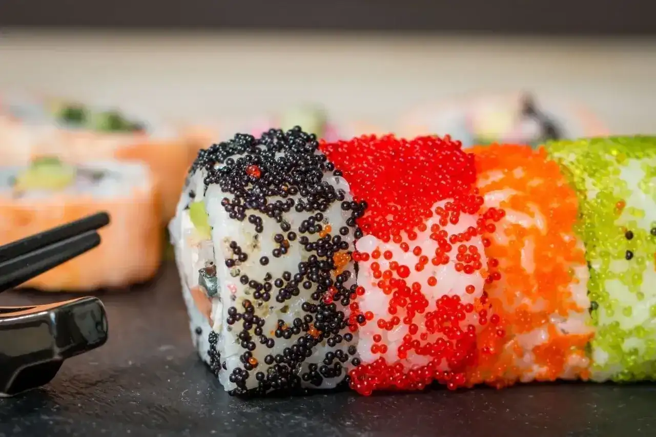Kolorowe rolki sushi z ikrą tobiko: czarną, czerwoną, pomarańczową i zieloną. Pyszne!