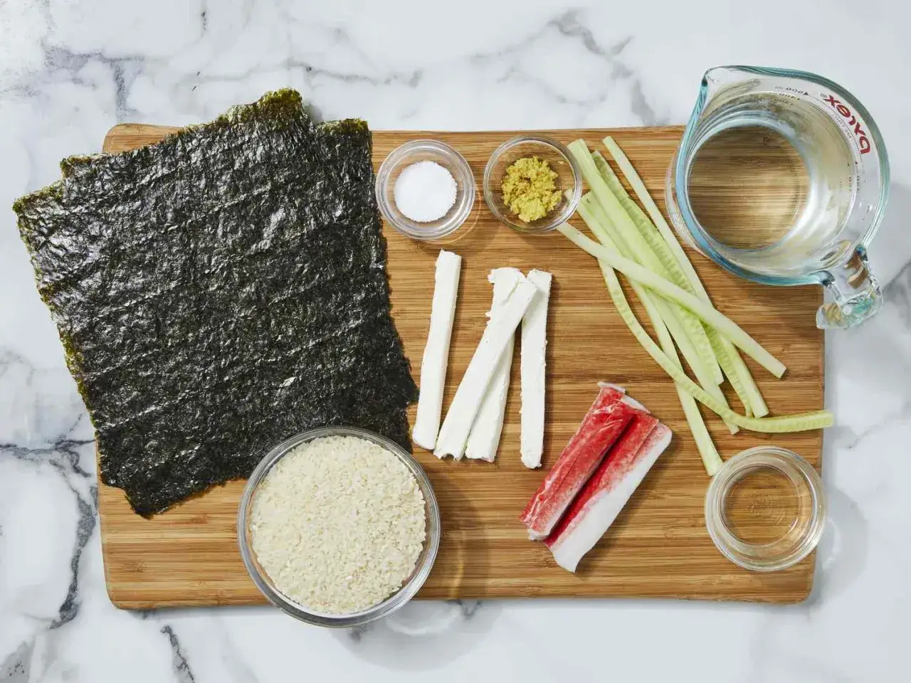 Składniki do sushi: ryż, nori, paluszki krabowe, ogórek, serek do sushi, imbir, sól, woda.