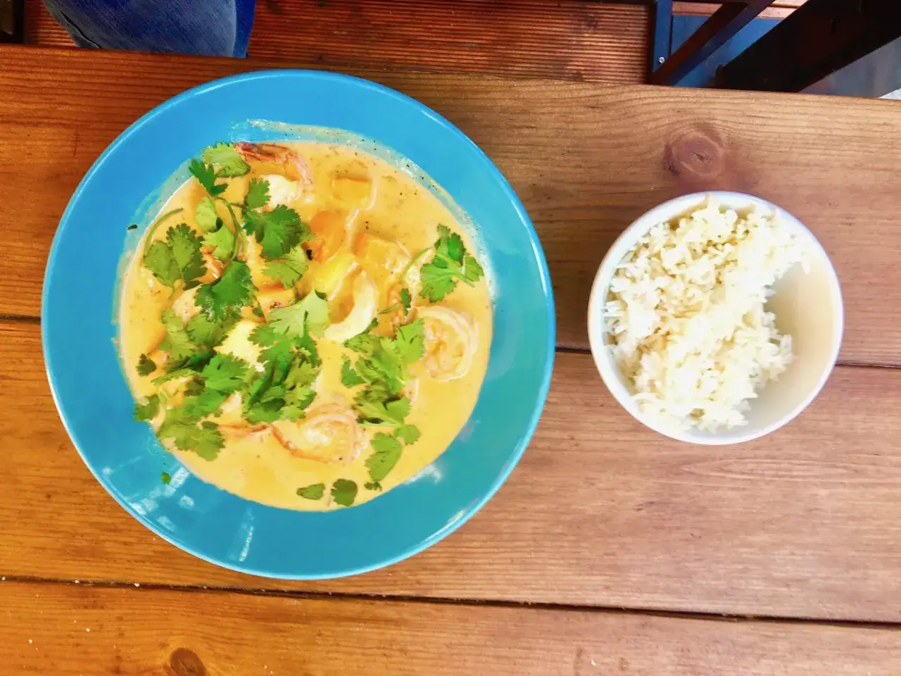 Krewetki w sosie curry z ryżem. Jak jeść krewetki w restauracji? Łyżką lub widelcem, delektując się każdym kęsem.