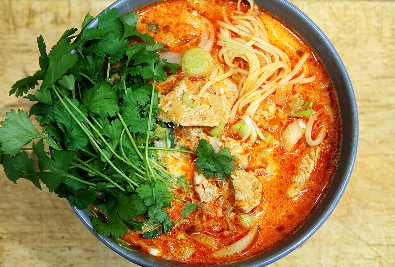 Aksamitna pasta z czerwonego curry z kawałkami mięsa, makaronem i świeżą kolendrą.