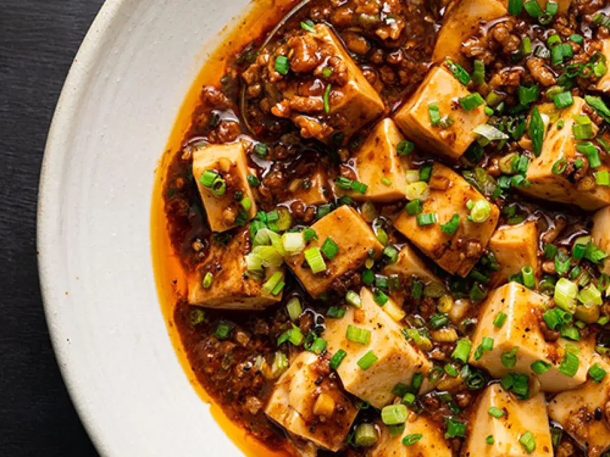 Pikantne danie z tofu i mielonego mięsa w sosie, klasyka kuchni sichuan, posypane szczypiorkiem.