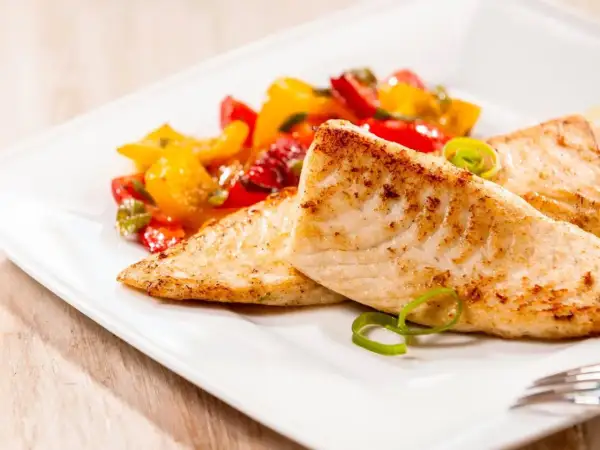 Smażona tilapia, delikatna ryba, podana z kolorowymi warzywami. Czy tilapia to ryba dla Ciebie?
