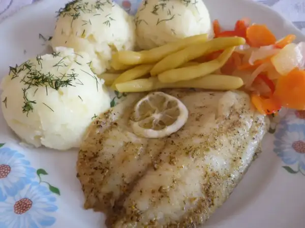 Smażony suflak z cytryną, podany z puree ziemniaczanym i warzywami.