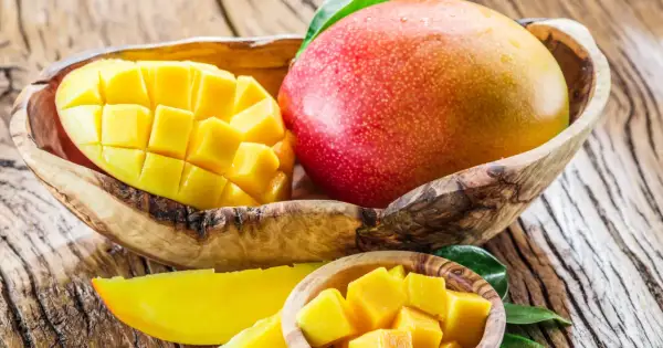 Słodkie, soczyste mango w drewnianej misce. Idealne na codzienne jedzenie mango, pełne witamin i słońca.